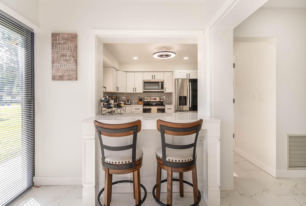 4760 Greentree Way, Unit A Boynton Beach, FL 33436 - Photo 10 of 30 a kitchen with stainless steel appliances kitchen island granite countertop a refrigerator and a stove