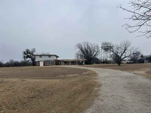 a front view of a house with a yard and large trees