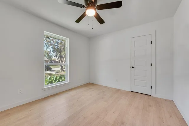 an empty room with fan and windows