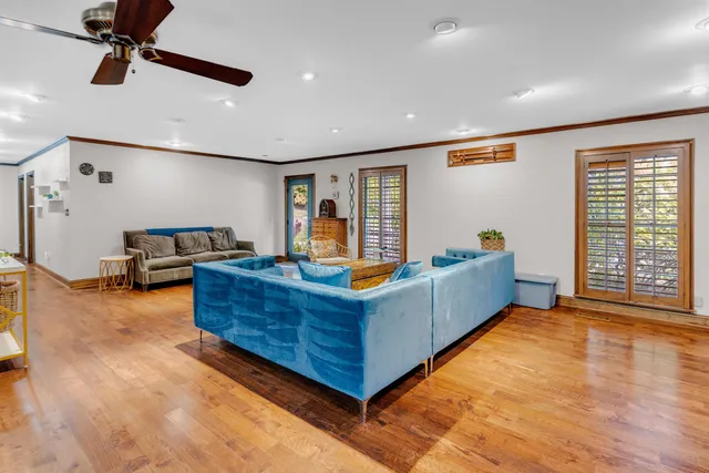 a living room with furniture a flat screen tv and a large window