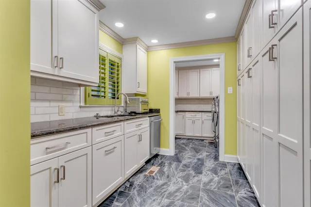 a bathroom with a granite countertop sink mirror vanity and toilet