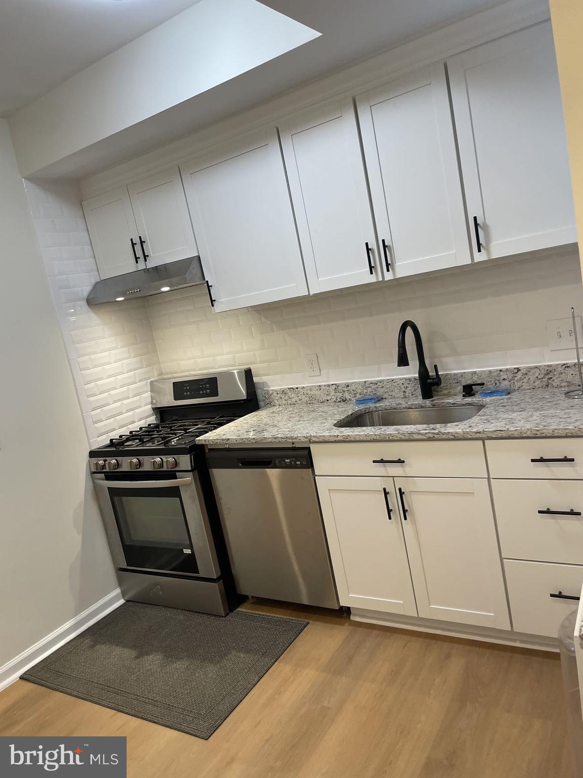 4 Hanover Place Northwest Washington, DC 20002 - Photo 3 of 6 a kitchen with granite countertop a sink and a stove top oven
