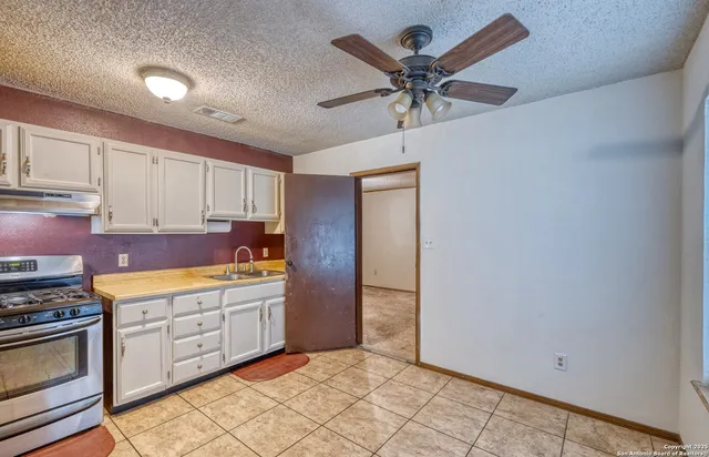 a kitchen with stainless steel appliances a cabinets and window