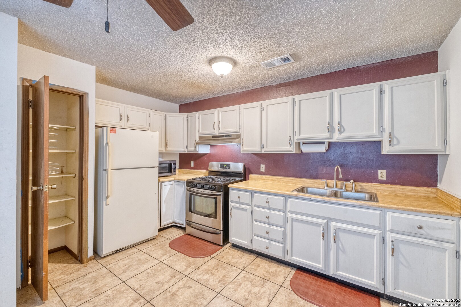 313 Bohme Street Uvalde, TX 78801 - Photo 8 of 23 a kitchen with stainless steel appliances granite countertop a refrigerator sink and cabinets