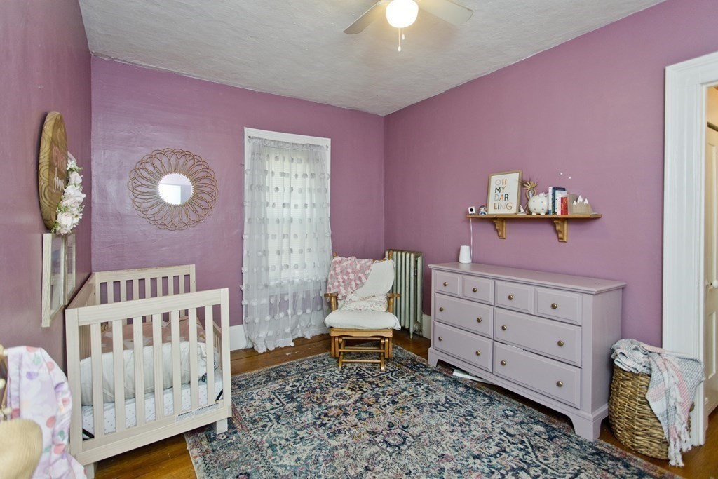 48-50 Howes Street Springfield, MA 01118 - Photo 15 of 38 a bedroom with a baby bed a dresser and a window