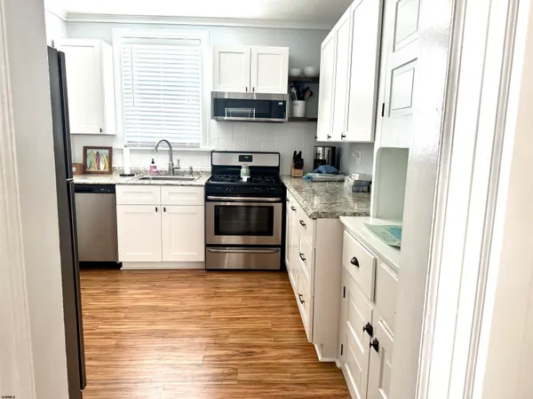 a kitchen with stainless steel appliances granite countertop a stove a sink and a refrigerator