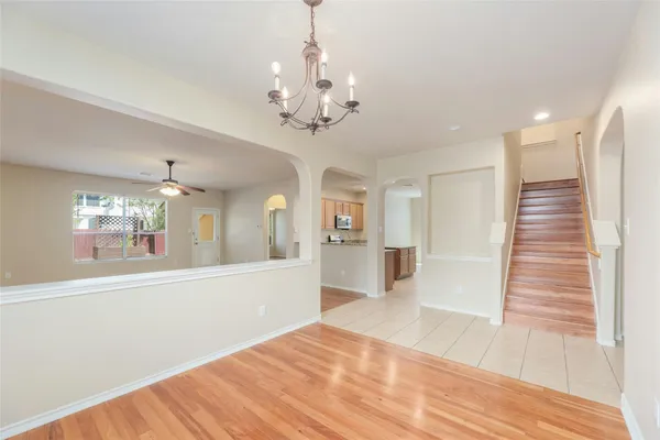 a view of a hallway with wooden floor and chandelier