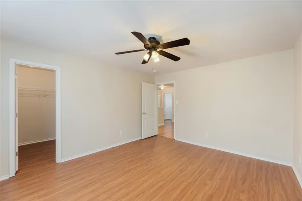 a view of a big room with wooden floor and a ceiling fan