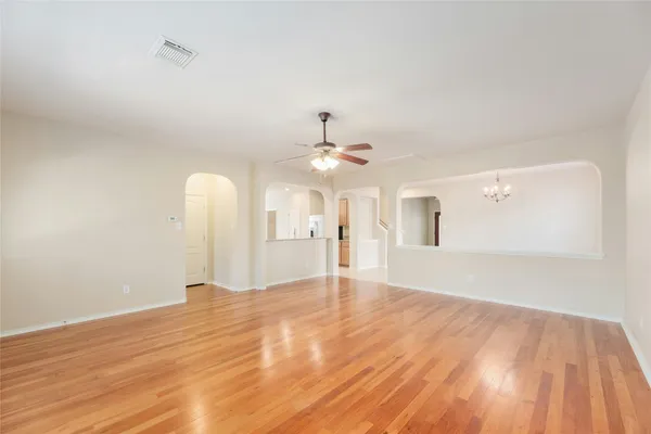 a view of an empty room with window and wooden floor