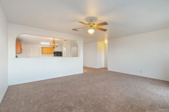 a view of a big room with chandelier fan
