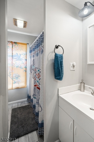 89 Trinity Street Newton, NJ 07860 - Photo 15 of 21 a bathroom with a sink a mirror and window