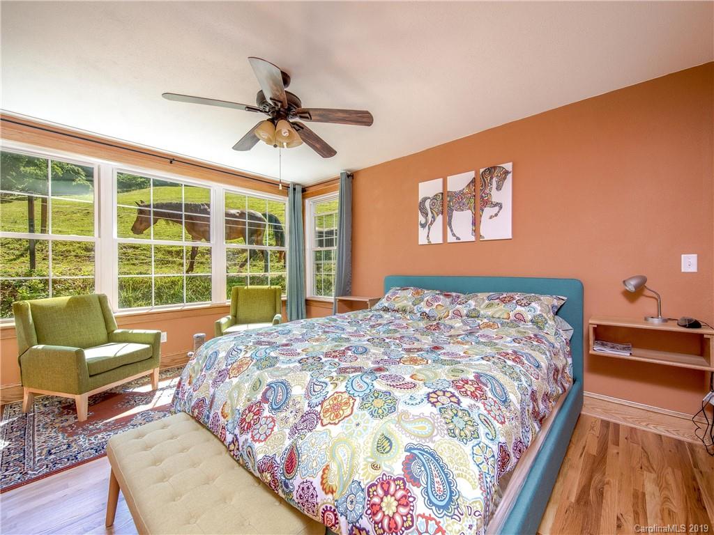 390 Grandview Road Canton, NC 28716 - Photo 18 of 42 a bedroom with a bed and a chandelier