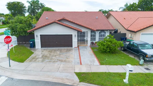 a aerial view of a house with a yard and potted plants