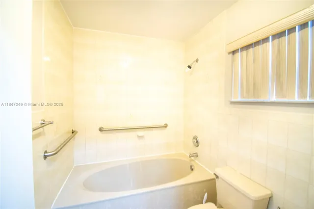 a white toilet sitting next to a bath tub