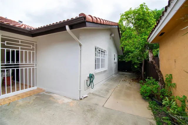 a view of a house with a yard and potted plants