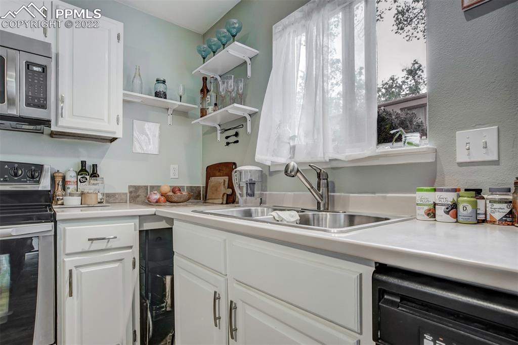 789 Alexander Road, Unit D Colorado Springs, CO 80909 - Photo 19 of 36 a kitchen with cabinets a sink and appliances