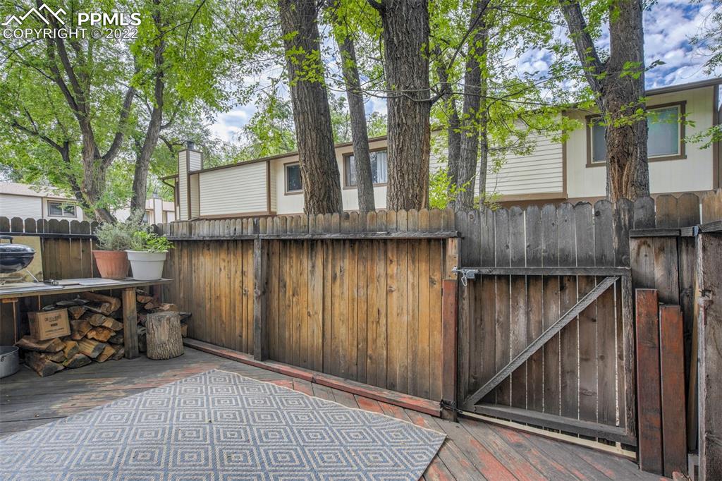 789 Alexander Road, Unit D Colorado Springs, CO 80909 - Photo 25 of 36 a backyard of a house with seating space and trees