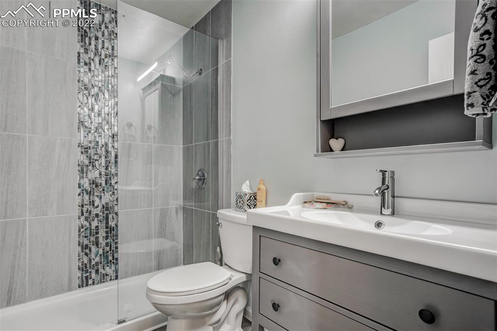789 Alexander Road, Unit D Colorado Springs, CO 80909 - Photo 6 of 36 a bathroom with a sink a toilet and shower