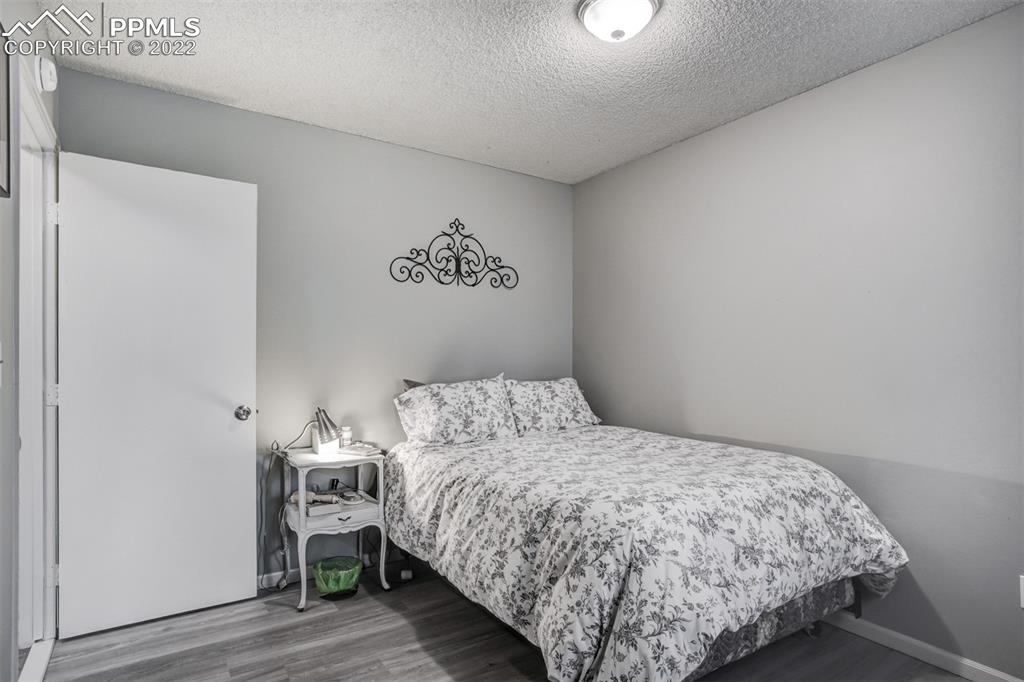 789 Alexander Road, Unit D Colorado Springs, CO 80909 - Photo 8 of 36 a bedroom with a bed and a table in it