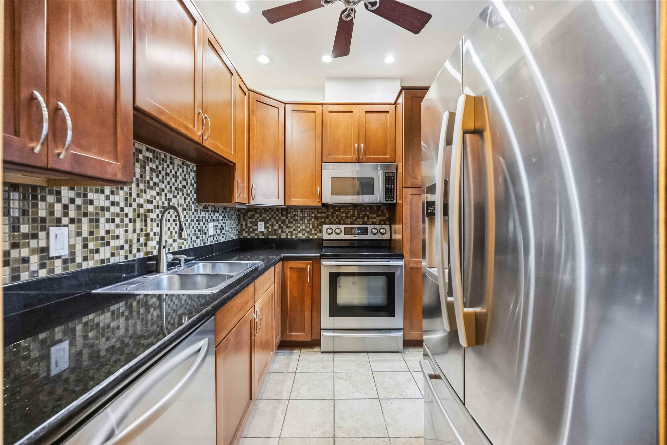 2100 Commonwealth Street, Unit C Houston, TX 77006 - Photo 9 of 25 a kitchen with granite countertop stainless steel appliances a refrigerator a sink and cabinets