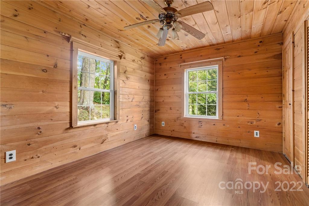 44 Jessella Drive Clyde, NC 28721 - Photo 24 of 37 an empty room with wooden floor and windows