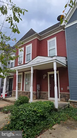 front view of a brick house with a small yard