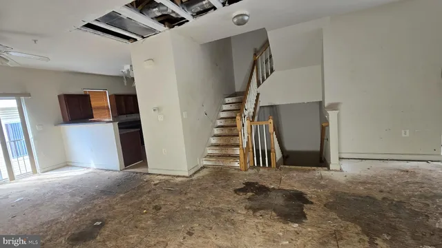 a view of a livingroom with wooden floor and stairs