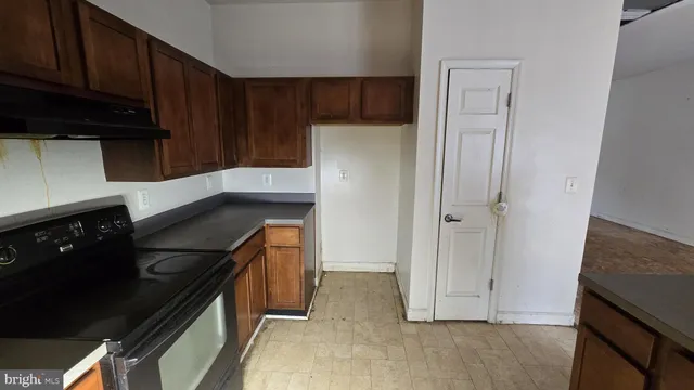 a kitchen with a refrigerator and a stove top oven