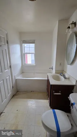 a bathroom with a sink vanity mirror bathtub shower and toilet