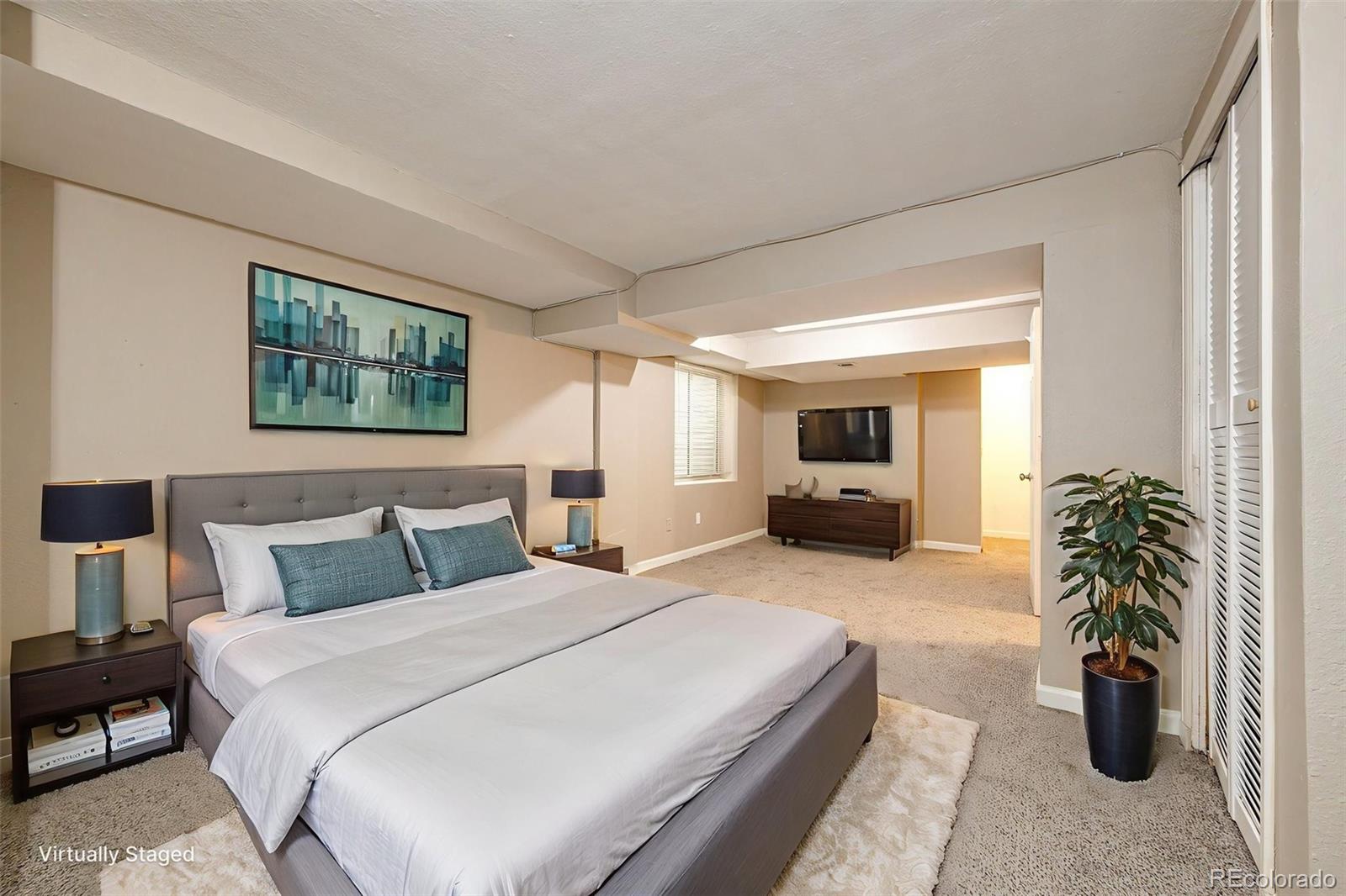 18538 East Whitaker Circle, Unit E Aurora, CO 80015 - Photo 21 of 31 a bedroom with a large bed and a potted plant