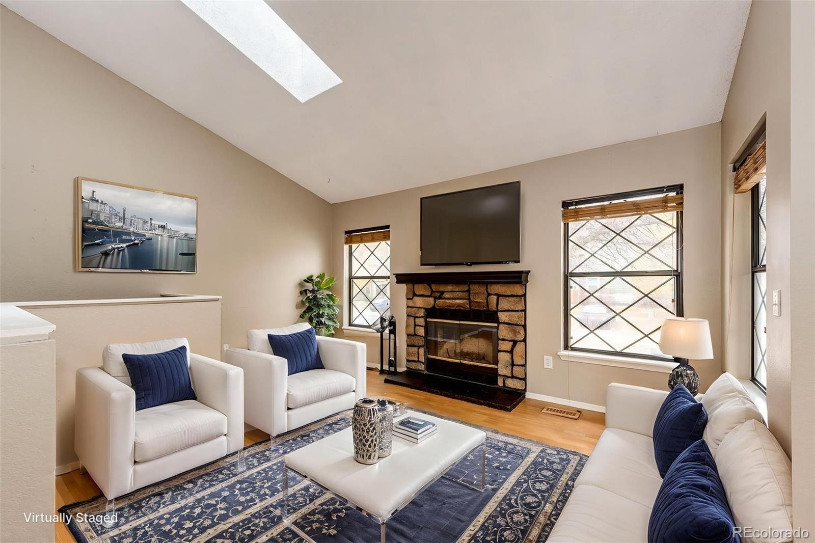 18538 East Whitaker Circle, Unit E Aurora, CO 80015 - Photo 9 of 31 a living room with furniture a flat screen tv and a fireplace