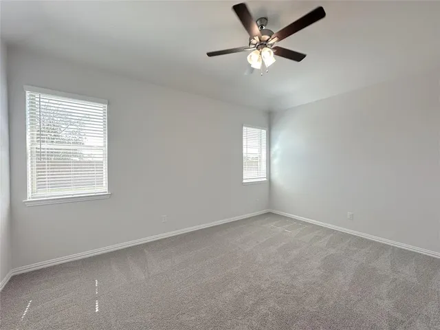 an empty room with a window and a fan