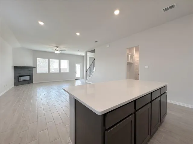 an empty room with a wooden floor and fireplace