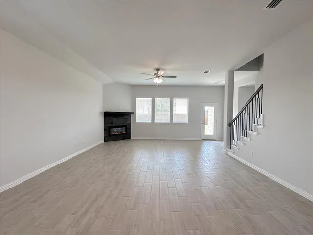 a view of a livingroom with wooden floor a fireplace and windows