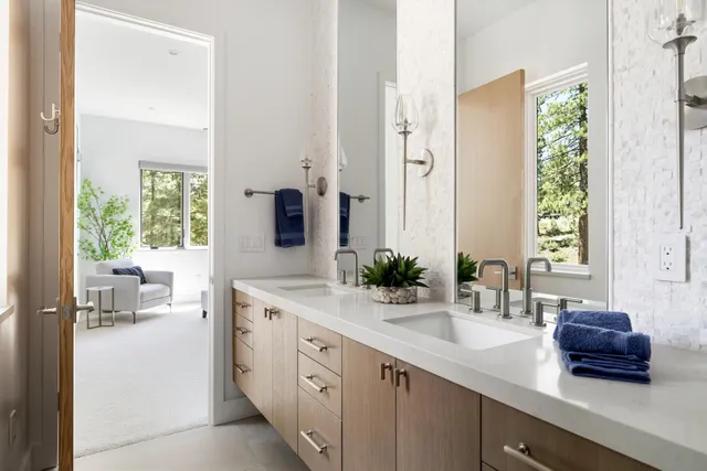 a spacious en suite bathroom with a double vanity sink and mirror