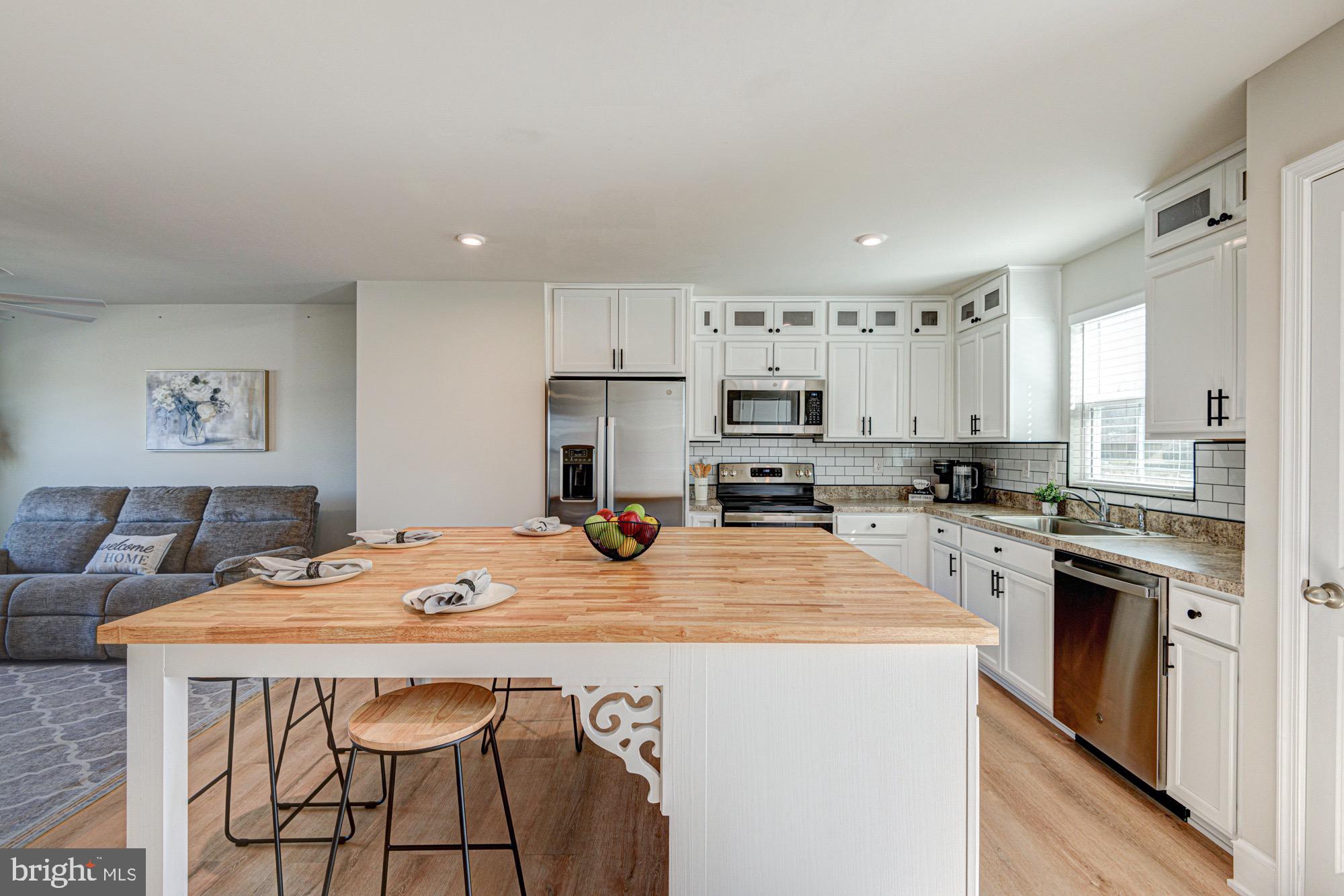 293 Sedimentary Rock Road Dover, DE 19904 - Photo 21 of 36 a kitchen with stainless steel appliances kitchen island granite countertop a kitchen island and chairs in it