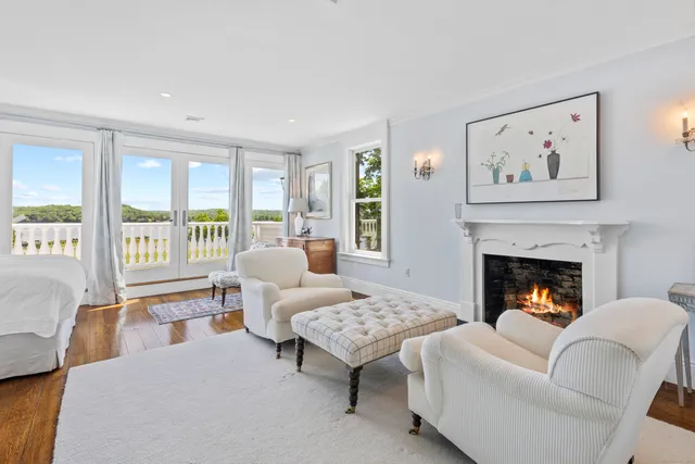 a living room with furniture two windows and a fireplace