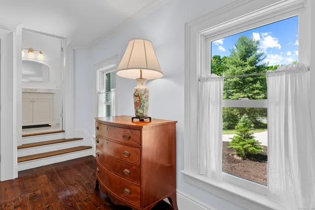 a view of a bedroom with wooden floor and windows