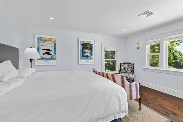 a bedroom with a bed and a large window