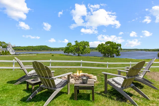 a view of a chair and table in backyard of the house