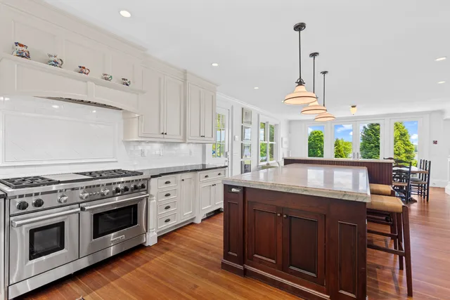 a kitchen with stainless steel appliances granite countertop a stove a sink and a wooden floors