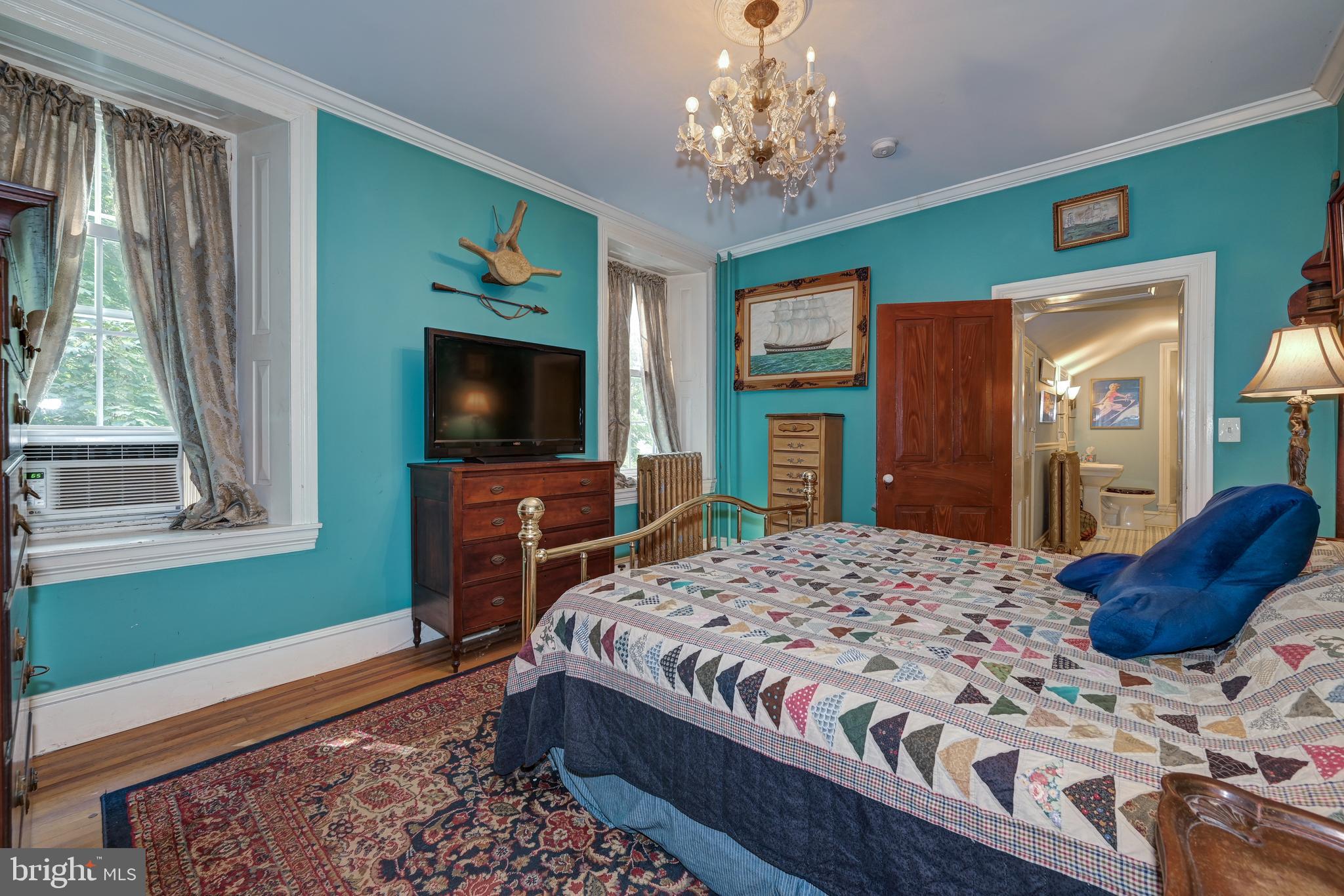 705 Woodlane Road Beverly, NJ 08010 - Photo 40 of 65 a bedroom with a large bed and a flat tv screen on dresser