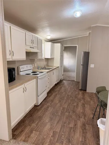 a large kitchen with a stove a sink dishwasher and a refrigerator