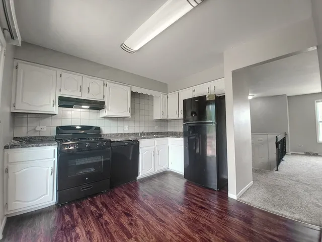 a kitchen with a refrigerator stove and wooden cabinets