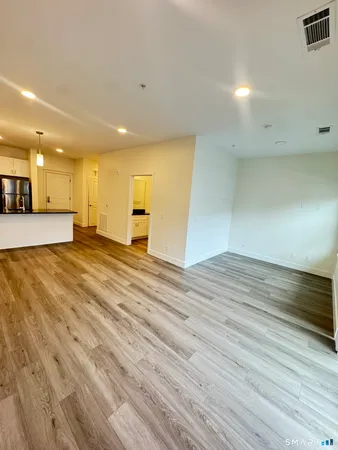 a view of an empty room with wooden floor