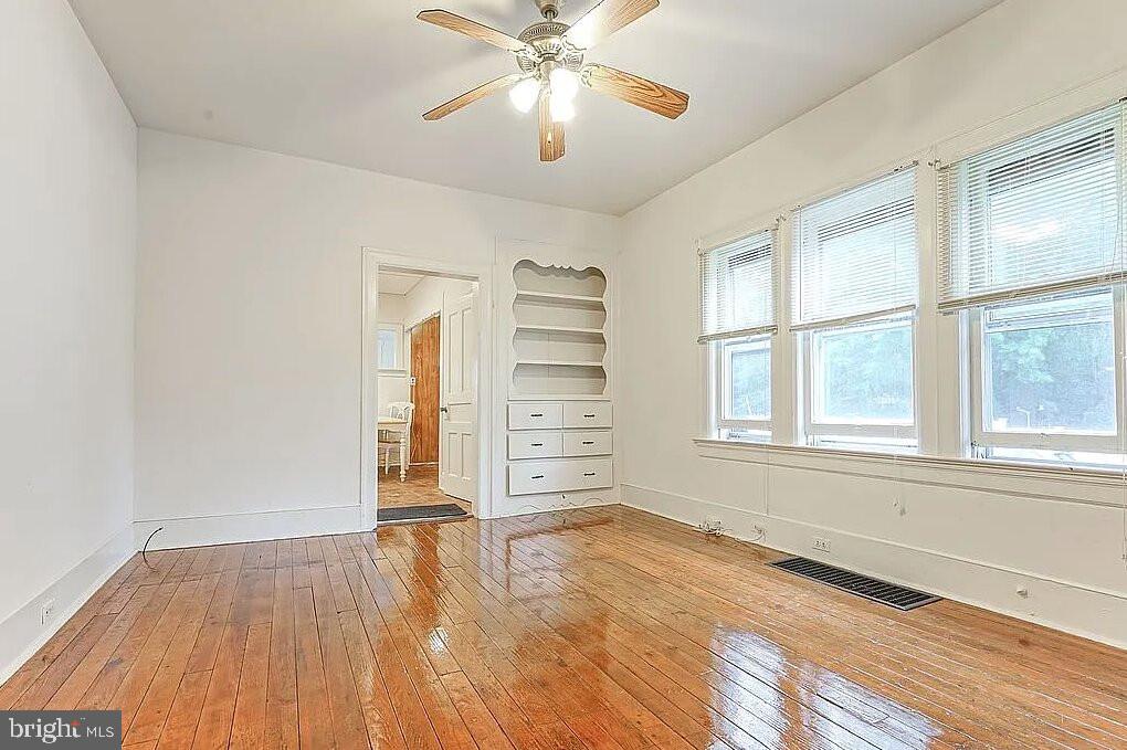 202 Cedar Avenue Pitman, NJ 08071 - Photo 7 of 11 a view of an empty room with a window and wooden floor