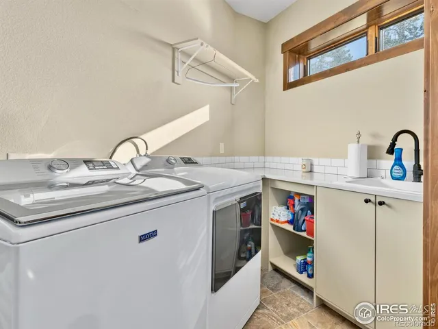 a utility room with sink dryer and washer