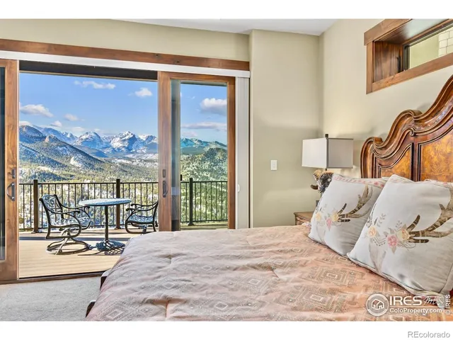 a bedroom with a balcony a bed and a large window