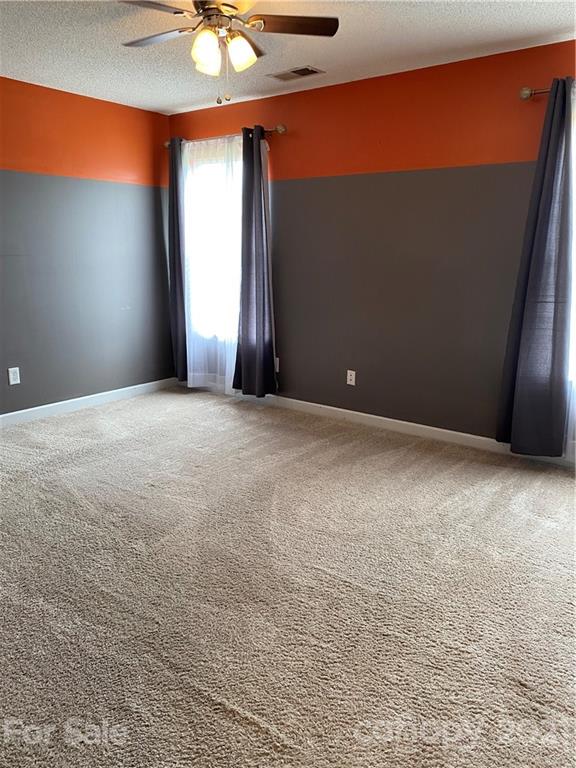 905 Lakehill Road Charlotte, NC 28214 - Photo 7 of 22 an empty room with windows and chandelier fan