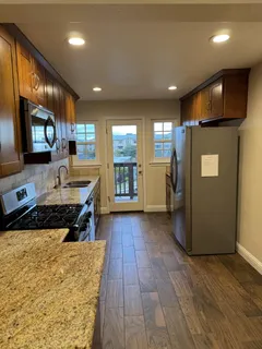 a kitchen with a refrigerator and a wooden cabinets